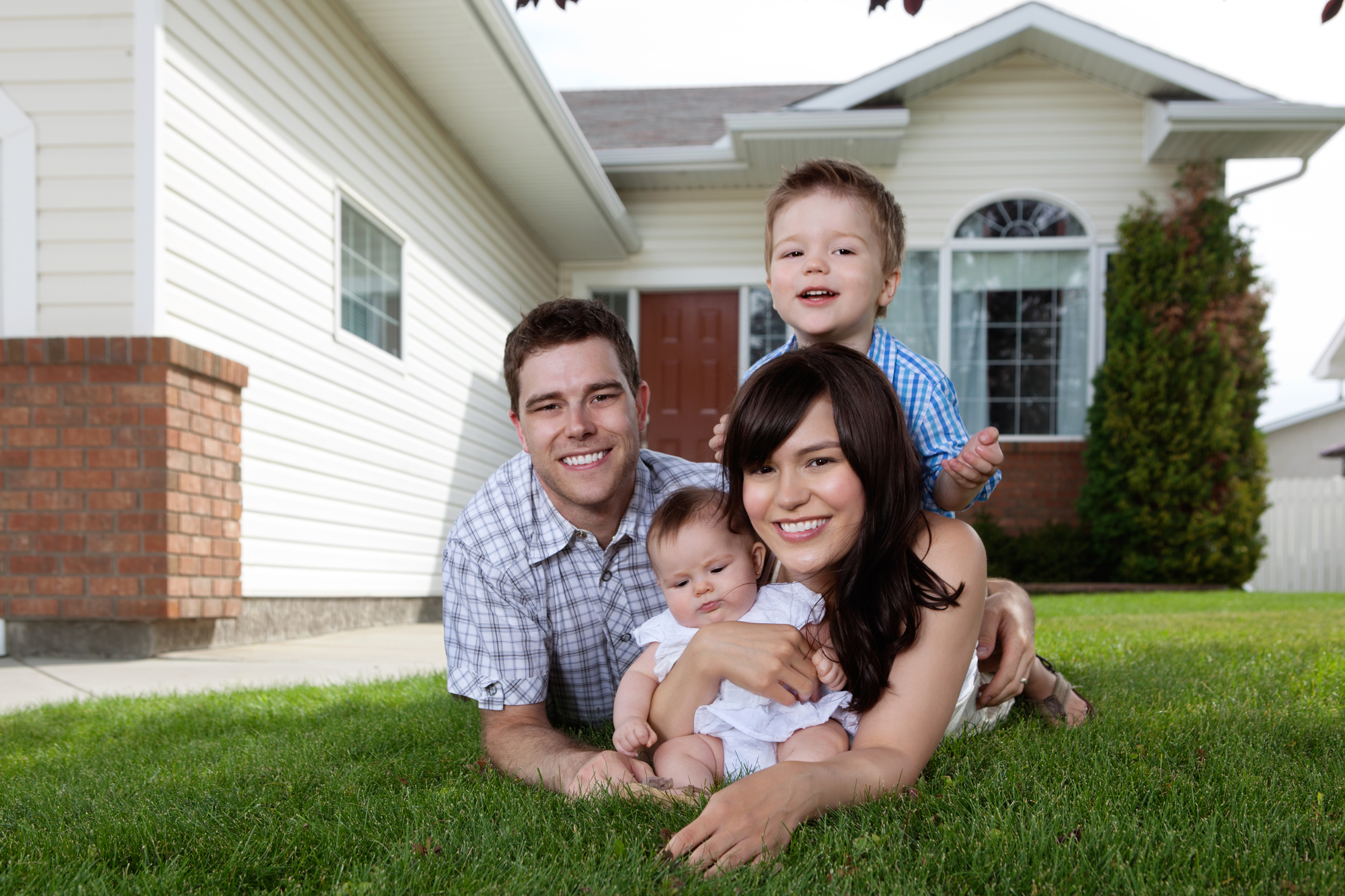 Family in front of a home about to obtain 2022 Enrollment Plans