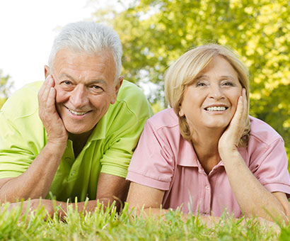 elderly couple laying in the grass while enjoying Medicare Supplement Plans in Brandon. 